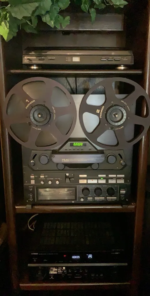 Walnut cabinet housing a Pioneer turntable, reel-to-reel tape deck, and modern Yamaha AV receiver